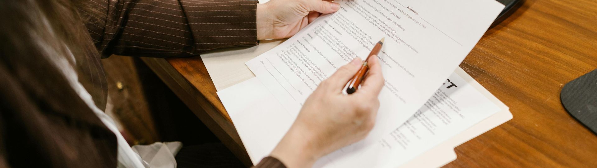 A lawyer examines divorce documents at a desk in a law office setting, emphasizing professionalism.